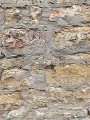Old sandstone wall background on which the dried mortar can be seen