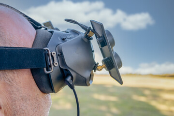 man with FPV HD goggles, piloting racing drone