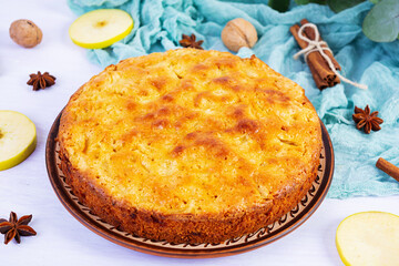 Delicious homemade apple pie on pink background. Apple pie with ingredients, apples and cinnamon