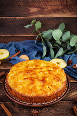 Delicious homemade apple pie on wooden background. Apple pie with ingredients, apples and cinnamon