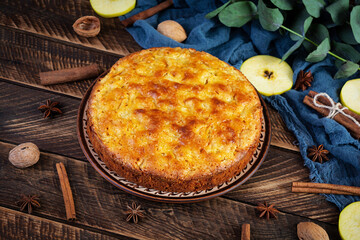 Delicious homemade apple pie on wooden background. Apple pie with ingredients, apples and cinnamon