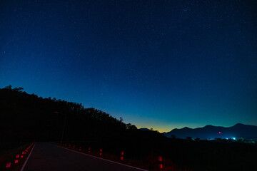 The Milky Way galaxy and mountain, road with stars and space dust in the universe, Long exposure photography with grain