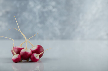 Pile of purple fresh radishes in the left side of photo