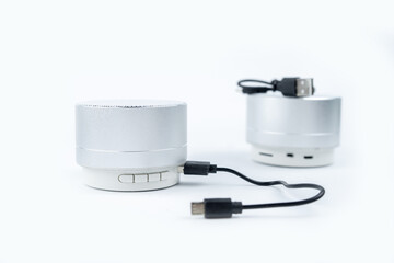 New wireless grey no name mini speakers with charging cable on white background