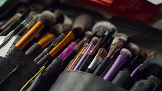 An assortment of makeup brushes. Handheld shot.
