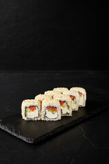 white rolls on black wooden board on black wooden background