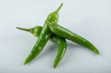 Pile of green hot peppers on white background