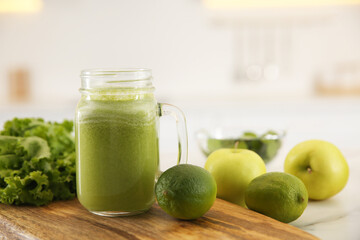 Tasty fresh juice in mason jar on board indoors, closeup. Space for text