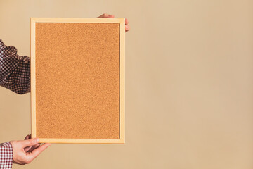 Image of man holding empty corkboard.