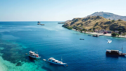 Fototapeta na wymiar A top down drone shot of paradise island in Komodo National Park, Flores, Indonesia. The island has scarcely any trees and bushes and is surrounded with idyllic white sand beaches. Island hoping