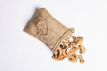 Forest dried edible mushrooms in sackcloth isolated on white background