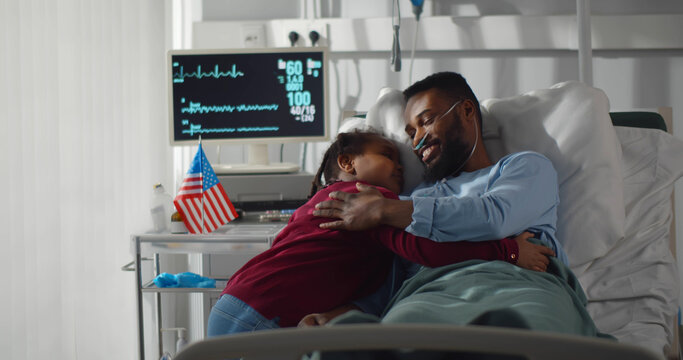 Adorable preteen black girl visiting sick dad in hospital