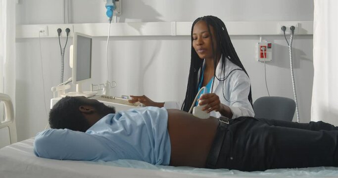 Woman doctor conducting ultrasound of patient abdomen and internal organs