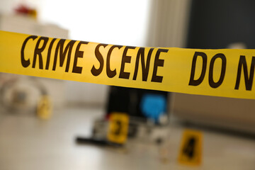 Crime scene with evidences and criminologist case, focus on yellow tape