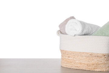 Soft towels in wicker basket on white background