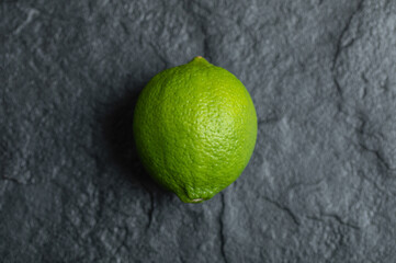 Close up photo of fresh ripe green lime on black background