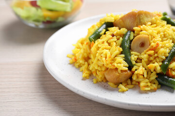 Delicious pilaf with chicken meat on wooden table, closeup