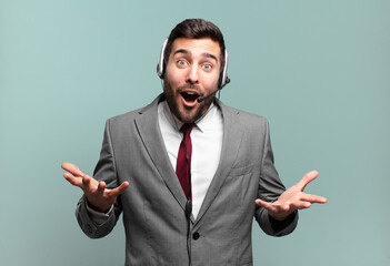 young businessman open-mouthed and amazed, shocked and astonished with an unbelievable surprise...