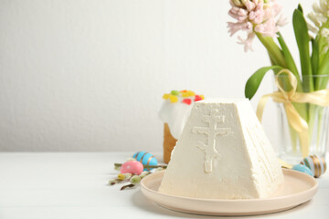 Traditional cottage cheese Easter paskha and eggs on white wooden table, space for text