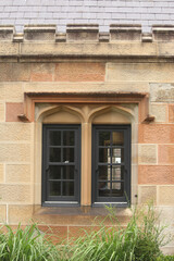 Fototapeta na wymiar Sandstone facade, windows and slate roof of Gardener’s Lodge in Victoria Park, Sydney