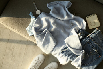 Soft cashmere sweater, jeans and accessories on sofa, flat lay