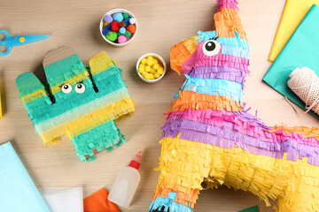Obraz premium Flat lay composition with cardboard cactus and donkey on wooden table. Pinata diy