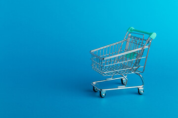 Shopping cart trolley on blue  background.