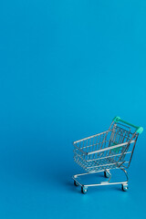 Shopping cart trolley on blue background.