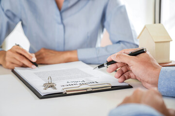 Real estate broker agent presenting and consult to customer to decision making sign insurance form agreement, home model, concerning mortgage loan offer for and house insurance