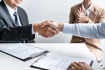 Greeting new colleagues, Handshake while job interviewing, male candidate shaking hands with Interviewer or employer after a job interview, employment and recruitment concept
