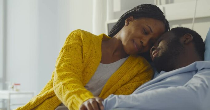 Happy african-american wife visiting smiling husband in hospital