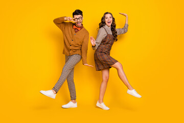 Full length photo of funky nice couple dance good mood make v-sign isolated on yellow color background
