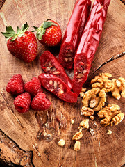 slicing Churchkhela, strawberries and nuts on a wooden background, top view, serving