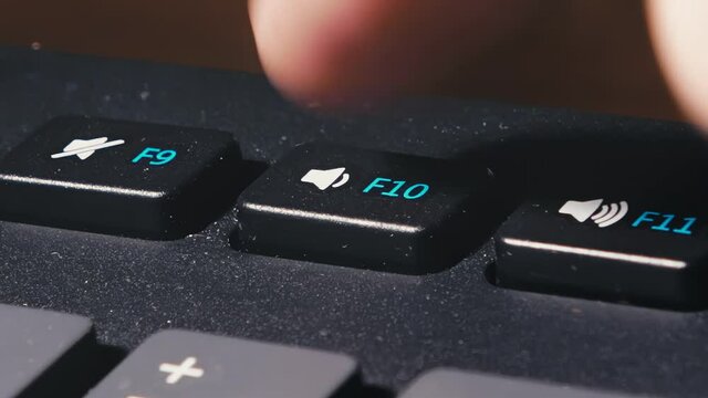 your finger presses the volume down key several times. the user decreases the volume of the sound. different key presses