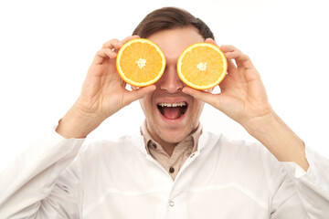 Portrait of a positive smiling male doctor nutritionist with oranges. Eat vitamin C, stay healthy, diet food in cold and flu season concept
