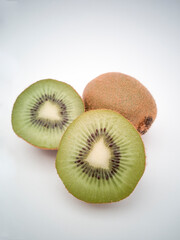 A close view on kiwi cut in half and group of kiwis on white background.
