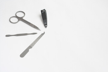 Metal manicure set, tweezers, scissors, file and spatula isolated on white background, copy space