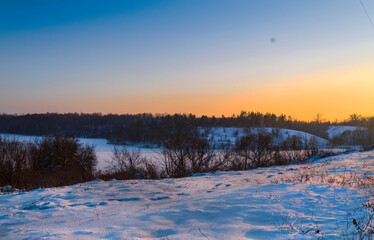 Fototapeta na wymiar Footsteps along the railway tracks in winter at sunset
