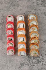 Variety of tasty sushi rolls placed on marble background