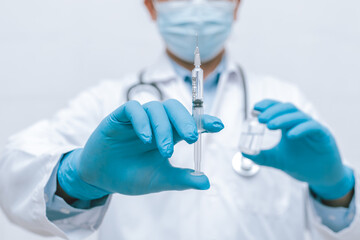 Doctor, nurse, scientist hand in blue gloves holding flu, measles, coronavirus, covid-19 vaccine disease preparing vaccination shot, medicine and drug concept.