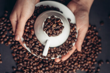 coffee beans white saucer and an inverted cup close-up dark background top view