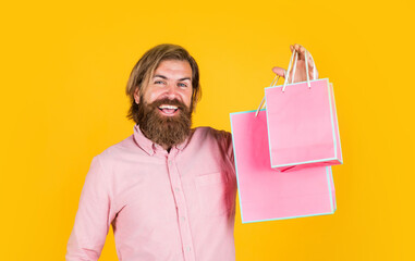 mature man with beard and trendy hairstyle hold gift package, shopaholic