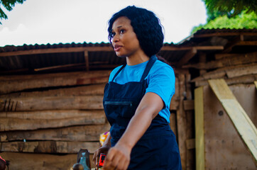 young pretty african female carpenter feeling as she is working in the store