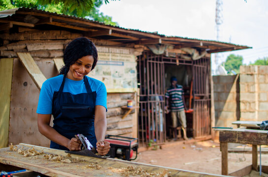 young pretty african female carpenter feeling as she is working in the store