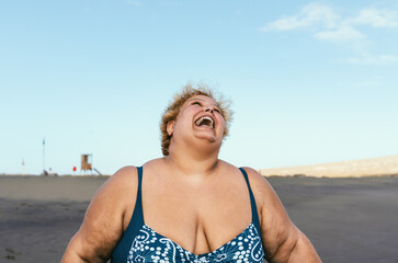 Happy plus size woman laughing on the beach - Curvy overweight model having fun during vacation in...