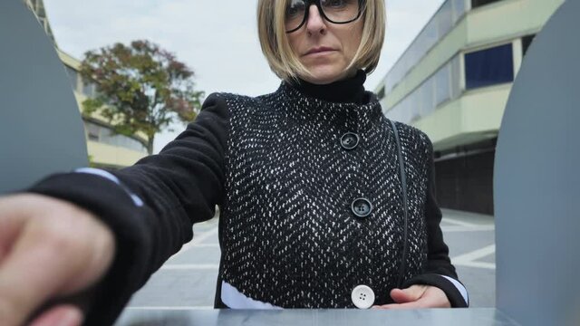 Caucasian woman taking money from cash machine bancomat camera point of view pov,female withdrawing from atm outdoor day shot