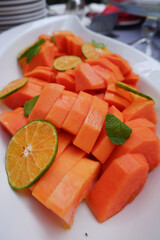 Fresh papaya slices and sweet orange on a plate. Healthy food