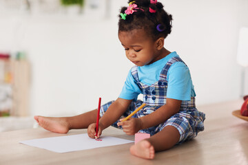 cute toddler baby girl drawing with pencils using both hands - 416781203
