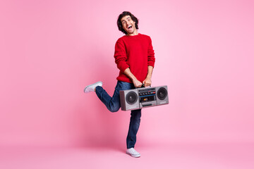 Full size photo of young man excited crazy happy positive smile hold boombox wear denim isolated over pastel color background