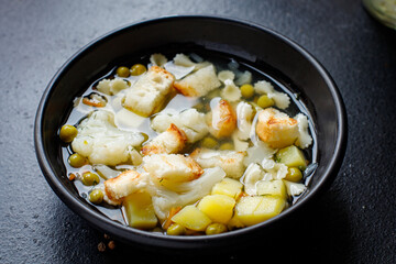 soup vegetable fine pasta first course broth, potatoe, cauliflower, onion, carrot, celery no meat vegetarian or vegan portion on the table meal snack top view copy space for text food background